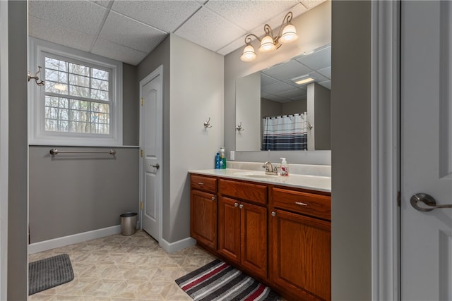 bathroom featuring a paneled ceiling, vanity, and walk in shower