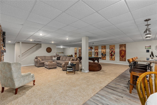 carpeted living room with a paneled ceiling and pool table