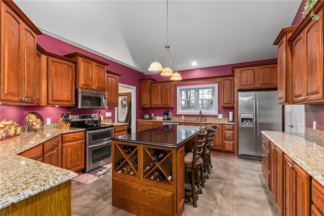 kitchen featuring light stone countertops, a center island, stainless steel appliances, an inviting chandelier, and pendant lighting