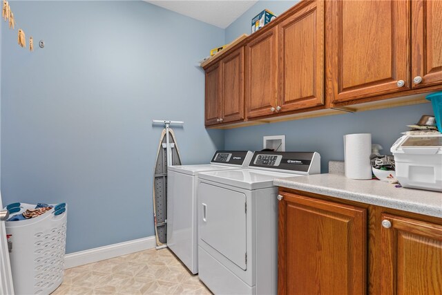 washroom with washing machine and dryer and cabinets