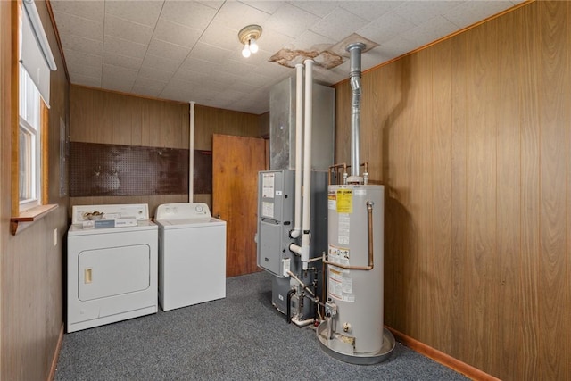 laundry area with wooden walls, gas water heater, carpet floors, laundry area, and washer and dryer