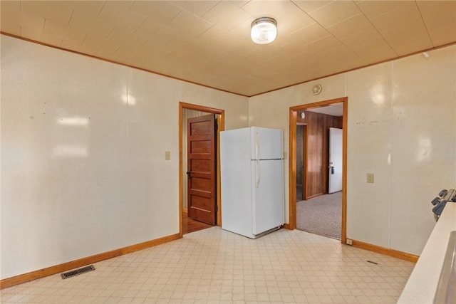 empty room with visible vents, light floors, baseboards, and ornamental molding