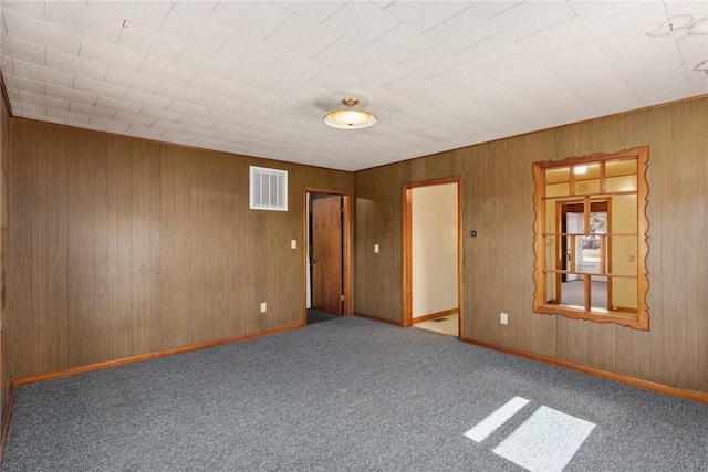 carpeted spare room with visible vents and baseboards