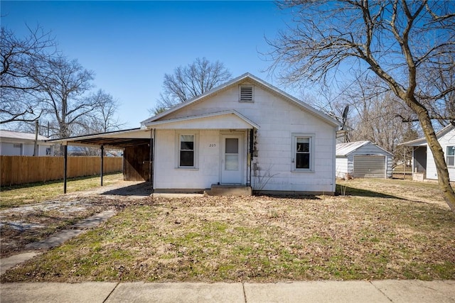 bungalow featuring a carport, fence, and a front yard