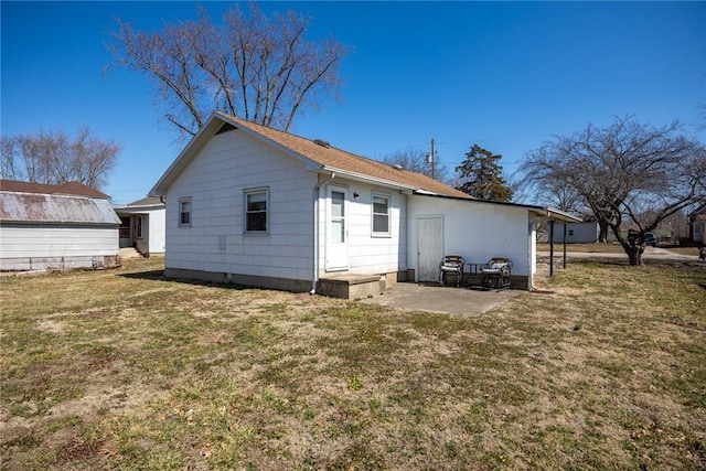 rear view of house with a patio area and a lawn