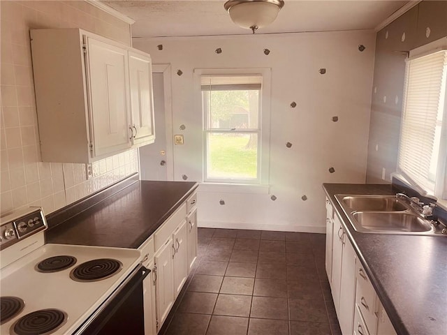 202 Elm St, Saint Elmo, IL 62458 - kitchen with electric range, a sink, dark countertops, white cabinetry, and crown molding
