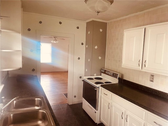 202 Elm St, Saint Elmo, IL 62458 - kitchen with white range with electric stovetop, crown molding, a sink, white cabinetry, and dark countertops
