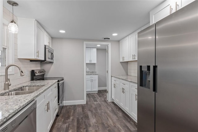 kitchen with stainless steel appliances, a sink, white cabinetry, and pendant lighting