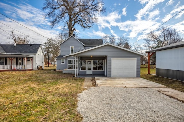 view of front facade with gravel driveway, a garage, a porch, and a front yard