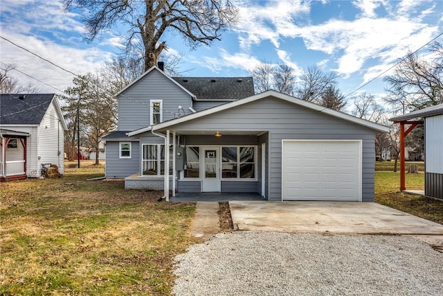 view of front of house featuring a garage, a front lawn, and gravel driveway