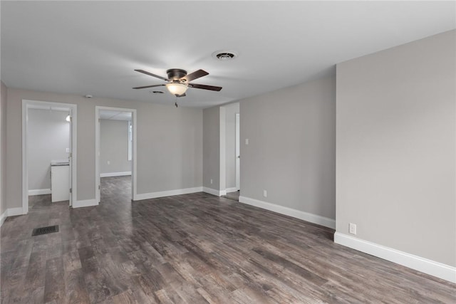 unfurnished room with baseboards, visible vents, and dark wood finished floors