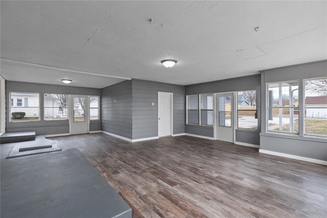 interior space featuring dark wood-type flooring, a textured ceiling, and baseboards