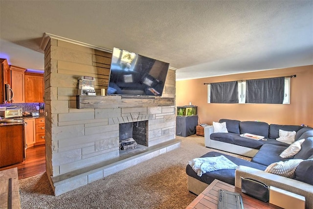 living area with carpet, a toaster, a fireplace, and a textured ceiling