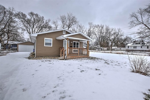 bungalow-style home featuring an outbuilding, a garage, and covered porch