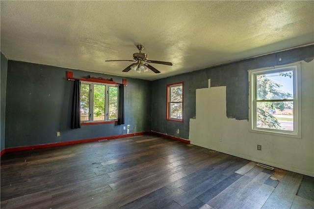 spare room with a textured ceiling, ceiling fan, plenty of natural light, hardwood / wood-style flooring, and baseboards