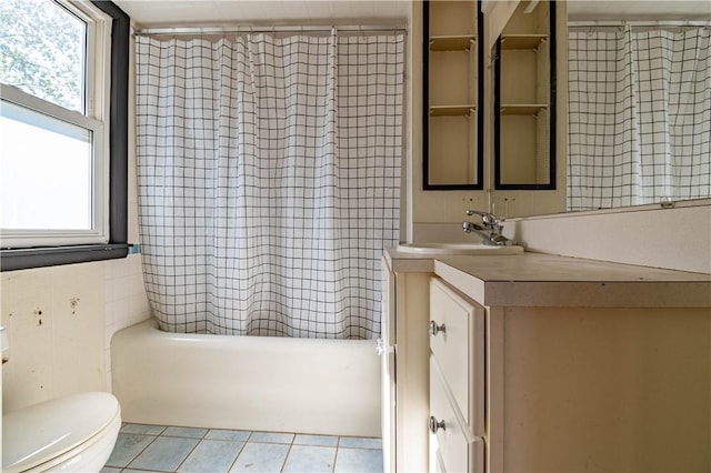 full bathroom featuring tile patterned floors, toilet, vanity, and shower / tub combo with curtain