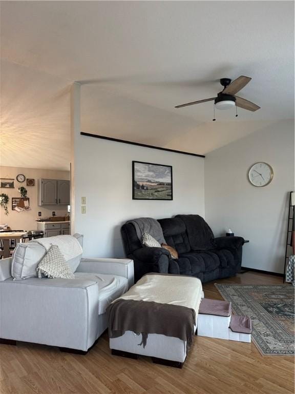 living area featuring a ceiling fan, lofted ceiling, and wood finished floors