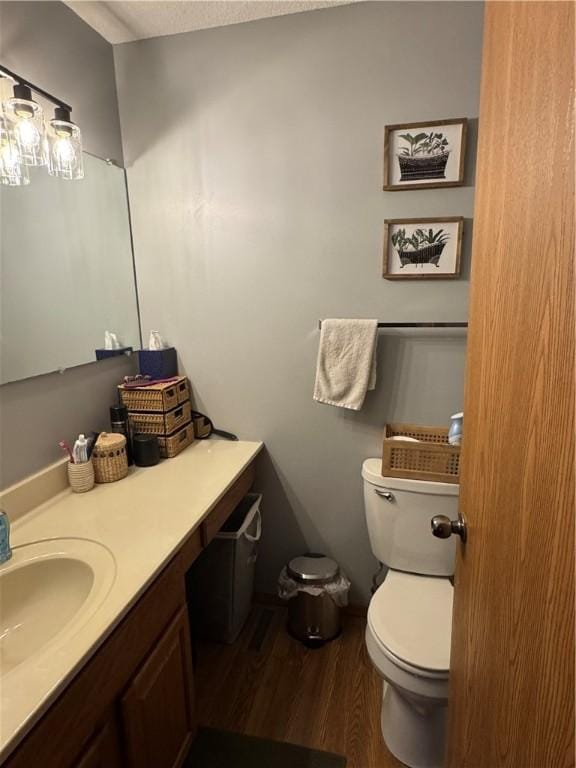 bathroom with vanity, toilet, and wood finished floors