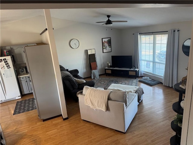 living room featuring lofted ceiling, ceiling fan, and light wood-type flooring