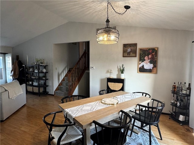 dining space with lofted ceiling, stairway, wood finished floors, and baseboards