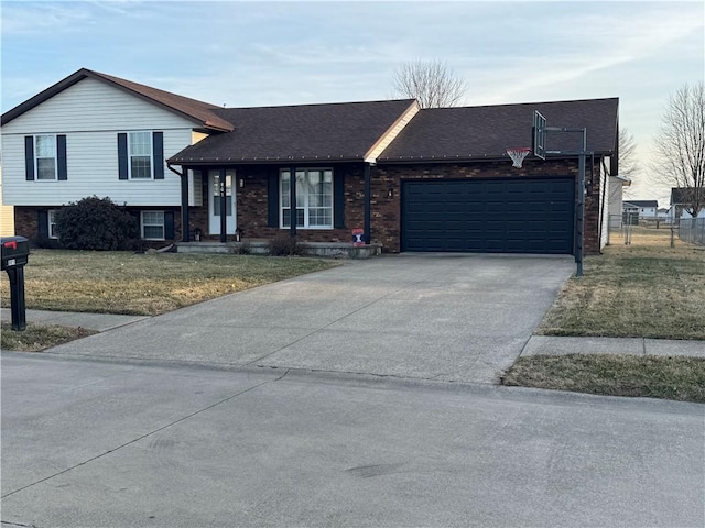 split level home with brick siding, fence, a garage, driveway, and a front lawn