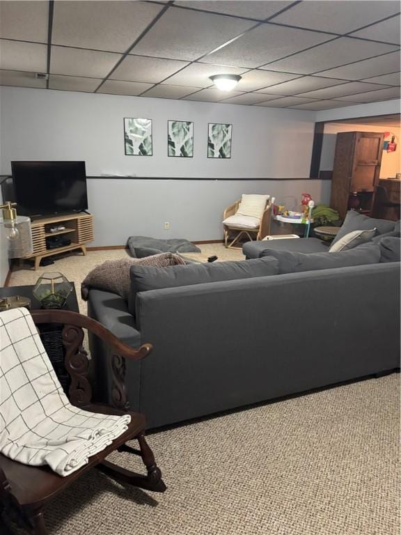 carpeted living room featuring a drop ceiling