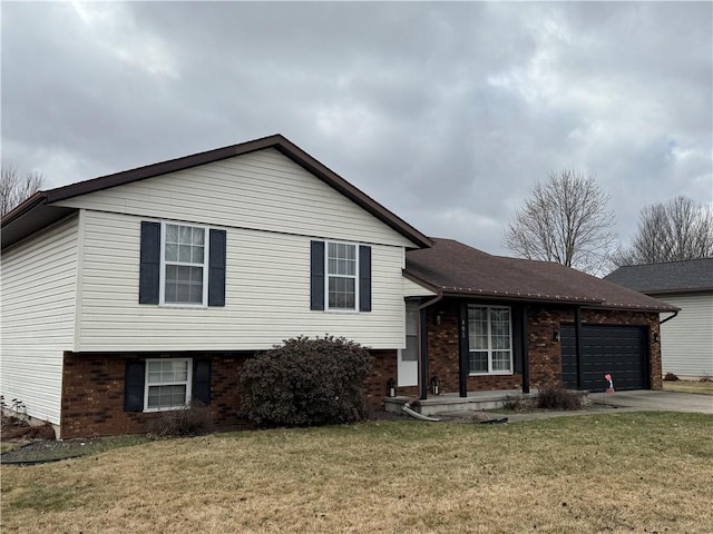 split level home with concrete driveway, brick siding, and a front yard