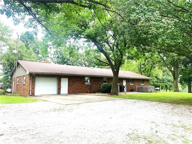 ranch-style house with a hot tub, a front lawn, and a garage