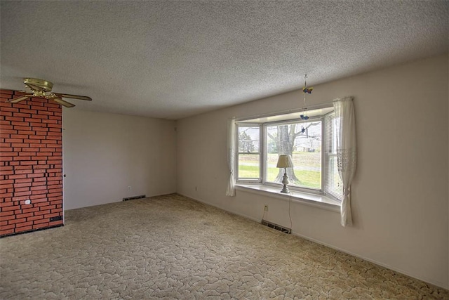 unfurnished room featuring carpet, visible vents, a textured ceiling, and a ceiling fan