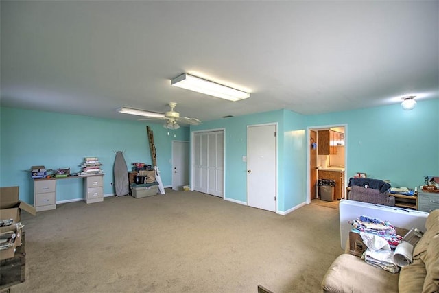 interior space with baseboards, a ceiling fan, and carpet floors