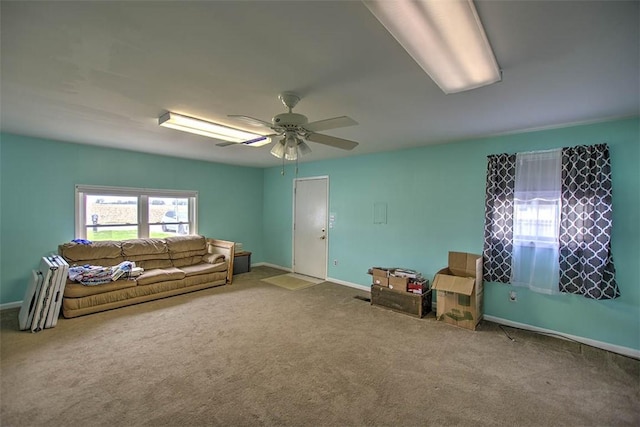 living room featuring carpet flooring, baseboards, and a ceiling fan