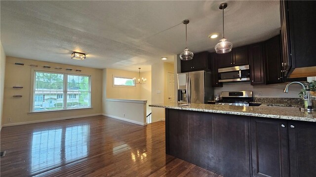 1009 E Grove Pl, Effingham, IL 62401 - kitchen featuring stainless steel appliances, a sink, dark wood-style flooring, baseboards, and light stone counters