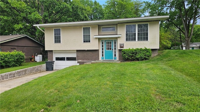 1009 E Grove Pl, Effingham, IL 62401 - split foyer home with concrete driveway, a garage, a front lawn, and brick siding