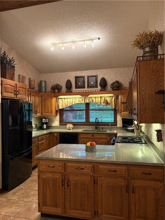 2236 Seneca Dr, Charleston, IL 61920 - kitchen featuring black appliances, a sink, a textured ceiling, brown cabinets, and light countertops