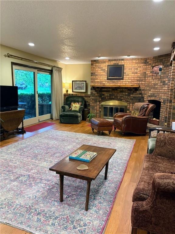 2236 Seneca Dr, Charleston, IL 61920 - living room featuring a brick fireplace, a textured ceiling, wood finished floors, and recessed lighting