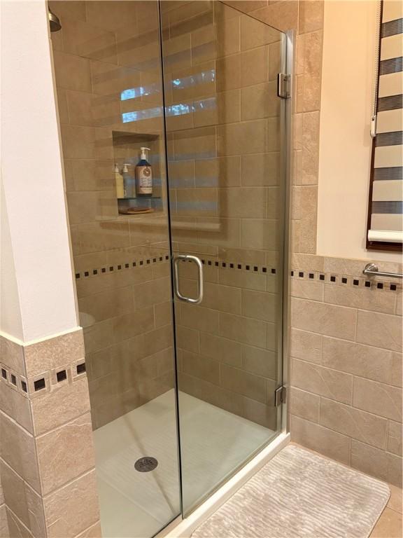 2236 Seneca Dr, Charleston, IL 61920 - bathroom with a stall shower, tile walls, and a wainscoted wall