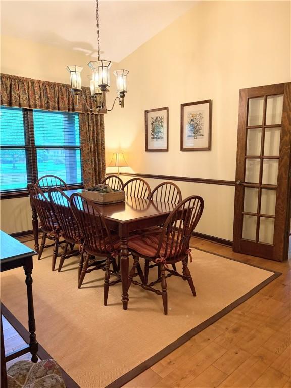 2236 Seneca Dr, Charleston, IL 61920 - dining space with a chandelier, wood finished floors, and lofted ceiling