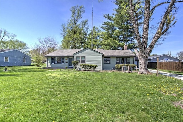 ranch-style home featuring fence, a chimney, and a front yard