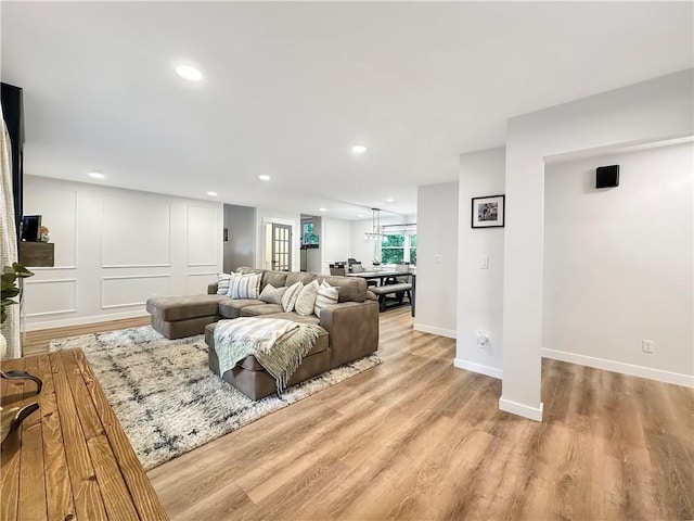 living room featuring light wood-type flooring, recessed lighting, and baseboards