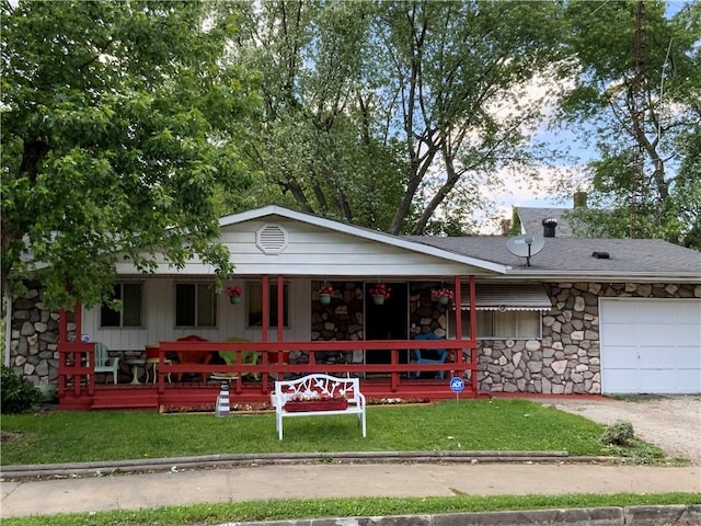 603 W English St, Danville, IL 61832 - single story home with covered porch, stone siding, a front lawn, and a garage
