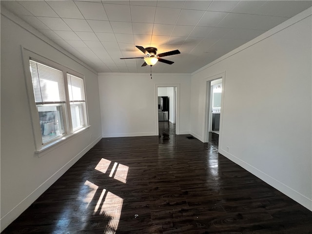 empty room with ceiling fan, dark hardwood / wood-style flooring, and crown molding