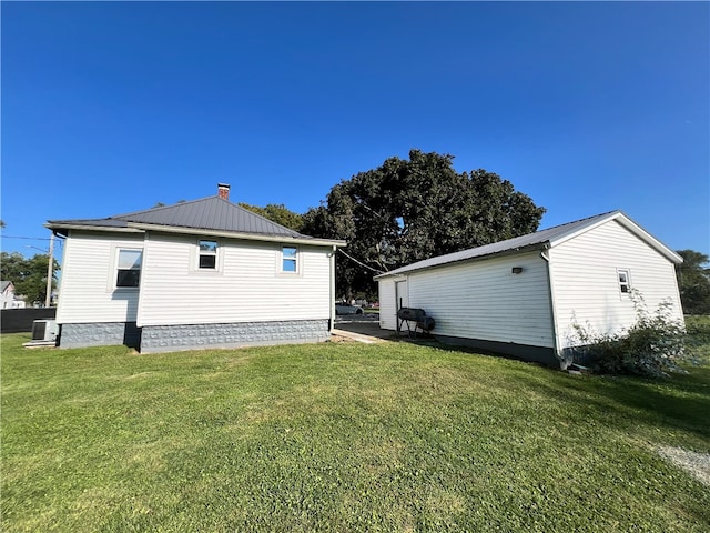 view of side of home featuring a yard and central AC unit