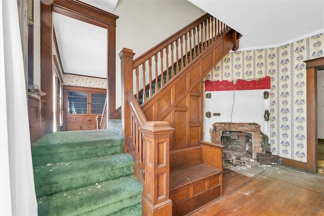 426 W Madison St, Paris, IL 61944 - stairs with wallpapered walls, wood finished floors, baseboards, a stone fireplace, and ornamental molding