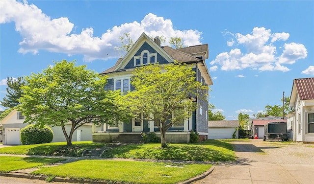 426 W Madison St, Paris, IL 61944 - view of front facade with a chimney, a garage, and a front yard