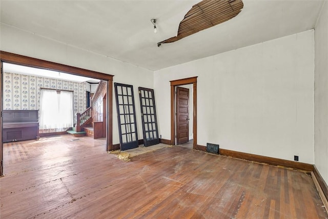 426 W Madison St, Paris, IL 61944 - empty room featuring hardwood / wood-style flooring, stairway, baseboards, and wallpapered walls