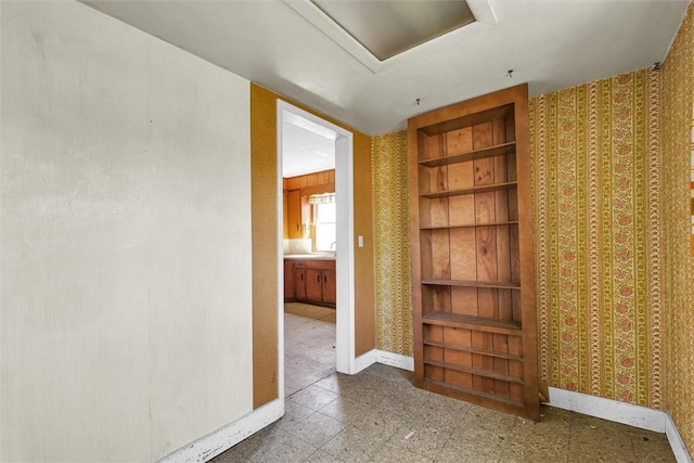 426 W Madison St, Paris, IL 61944 - empty room with attic access, baseboards, wallpapered walls, built in shelves, and a sink