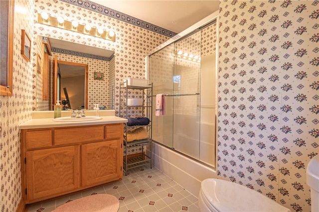5353 E Reas Bridge Rd, Decatur, IL 62521 - bathroom with wallpapered walls, toilet, tile patterned floors, vanity, and shower / bath combination with glass door
