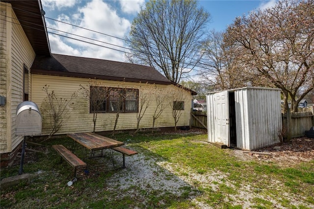 311 Lafayette St, Newton, IL 62448 - exterior space with an outdoor structure, roof with shingles, fence, and a storage unit