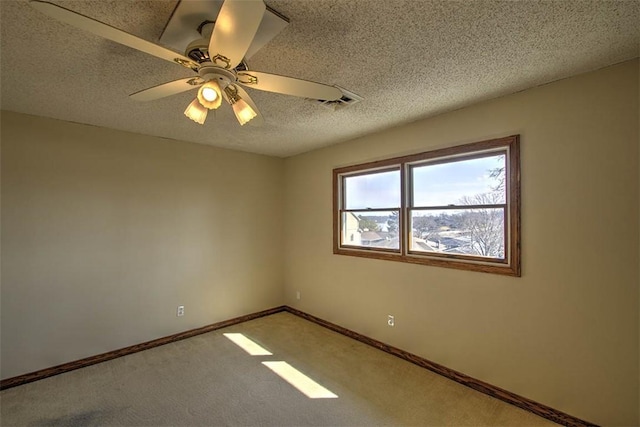 unfurnished room featuring a ceiling fan, light colored carpet, a textured ceiling, and baseboards