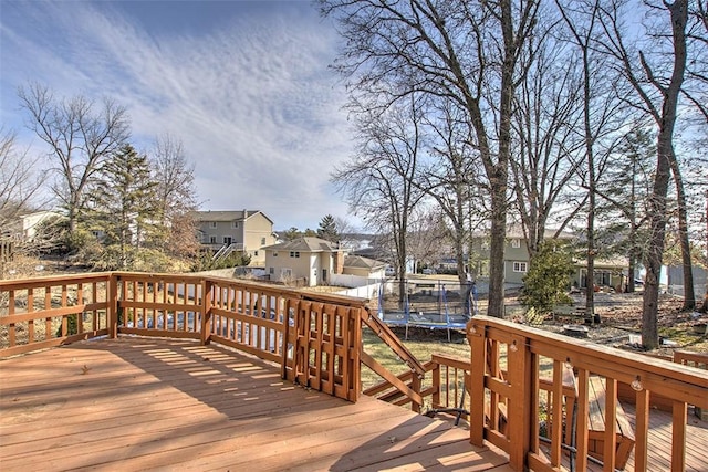 wooden deck featuring a trampoline and a residential view